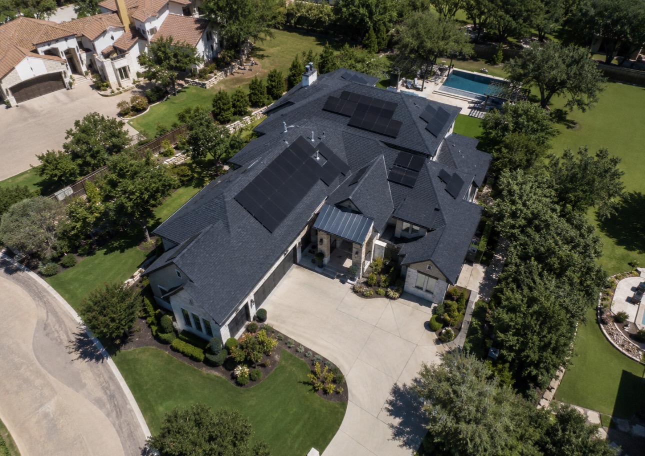 Aerial view of a large Texas estate with an extensive rooftop solar installation